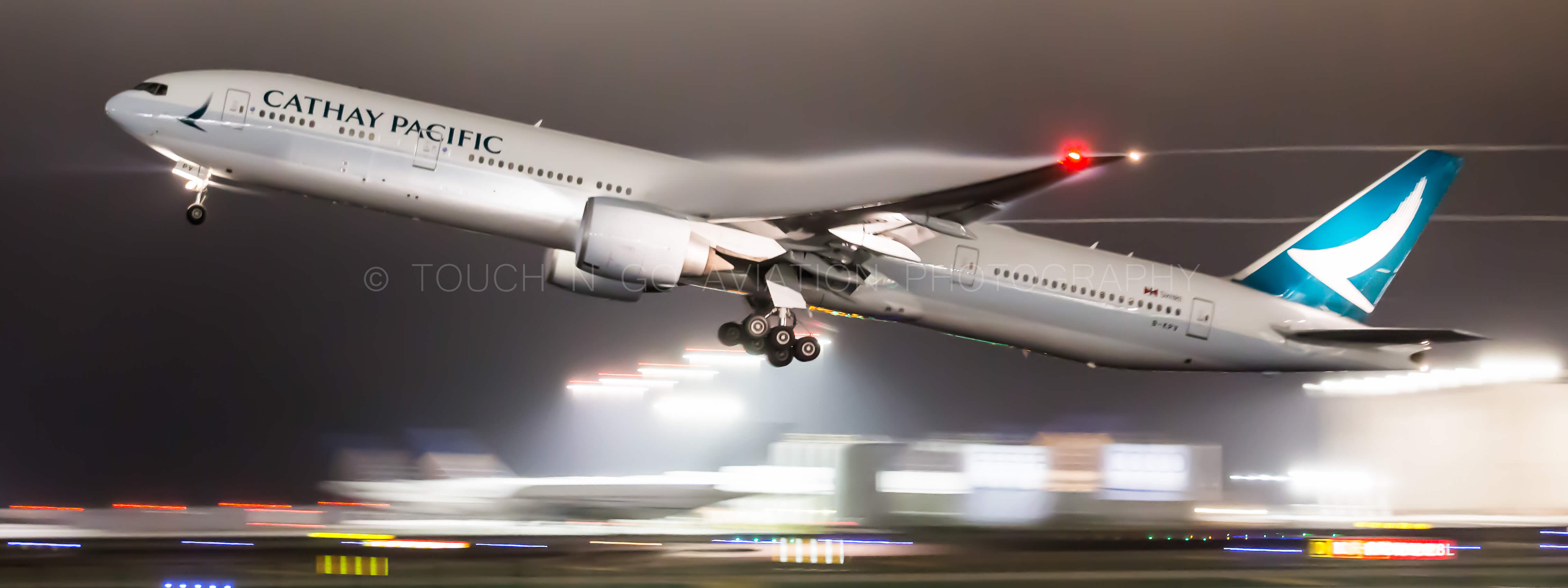 Cathay Pacific 777 departing out of SFO for HKG with cool condensation trailing off the wings.
