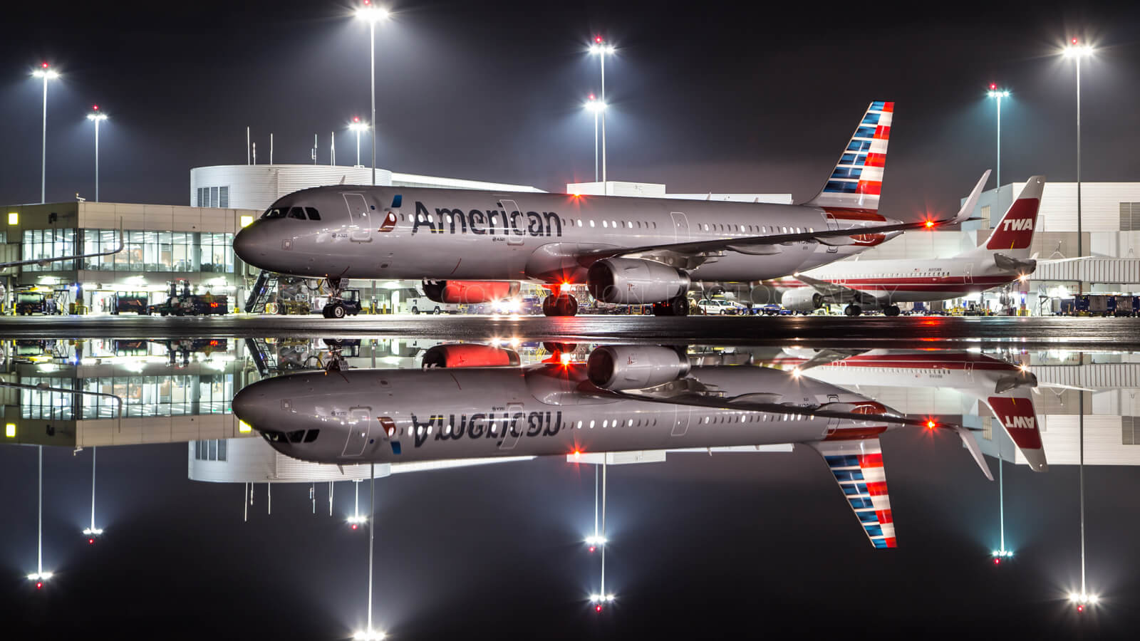 Perfect mirror image of AA afterpushback before taxi with TWA retro livery in background, SFO terminal 2.