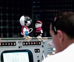Snoopy and Charlie Brown dolls on top of a console in the Mission Operations Control Room during Apollo 10 Lunar Orbit.