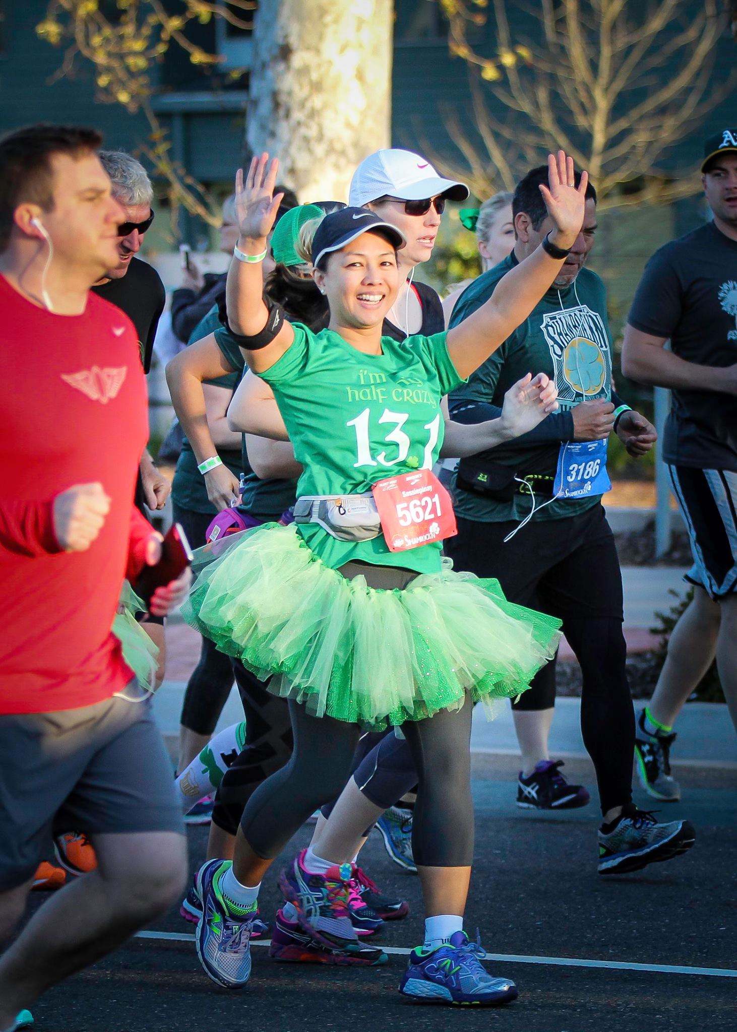 Christine happily running along in the Shamrock Half Marathon, wearing a green tutu outfit