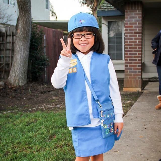 Rhiannon wearing her girl scout uniform, giving the peace sign