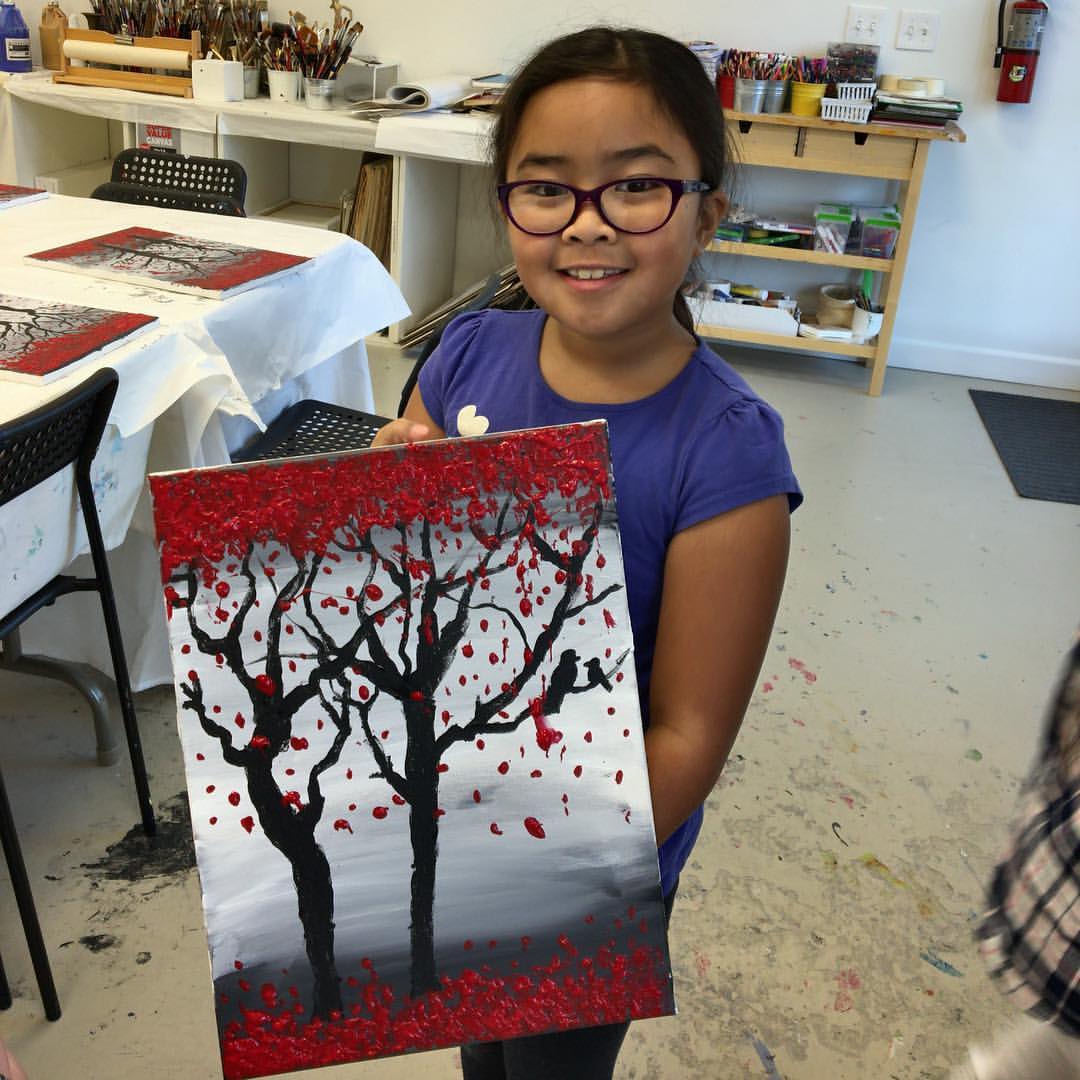 Rhiannon showing off the painting she made in art class